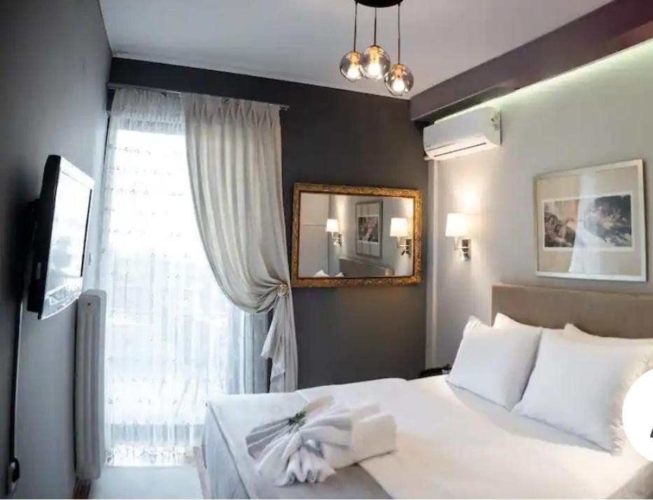 een slaapkamer met een wit bed en een raam bij Filoxenia Luxury Home Ioannina in Ioannina
