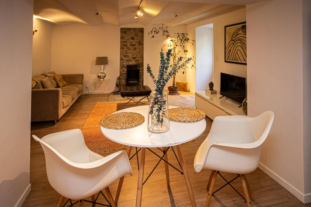 a living room with a white table and chairs at Beautiful converted one bedroom apartment in Carcassonne