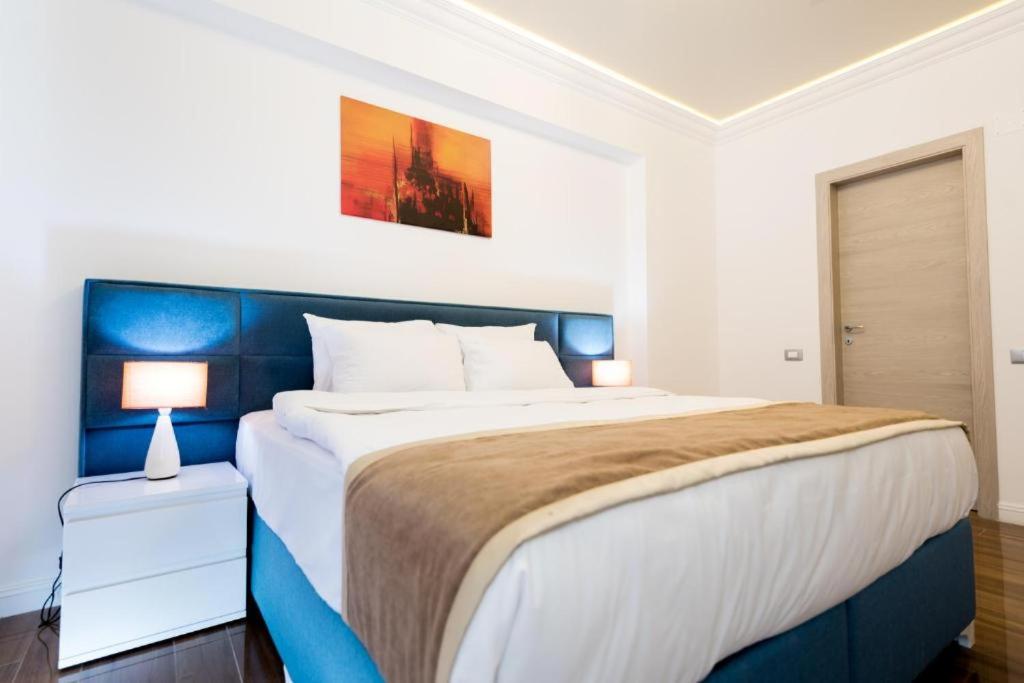 a bedroom with a large bed with a blue headboard at White Tower Mamaia Apartament Privat 503 in Mamaia