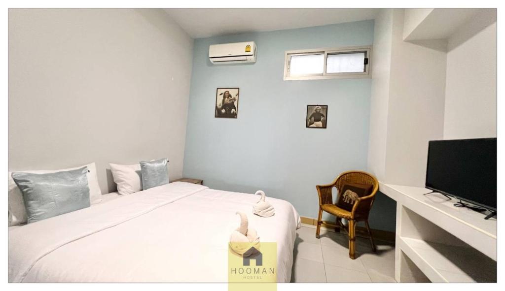 a bedroom with a bed and a television at Hooman Hostel in Chiang Mai