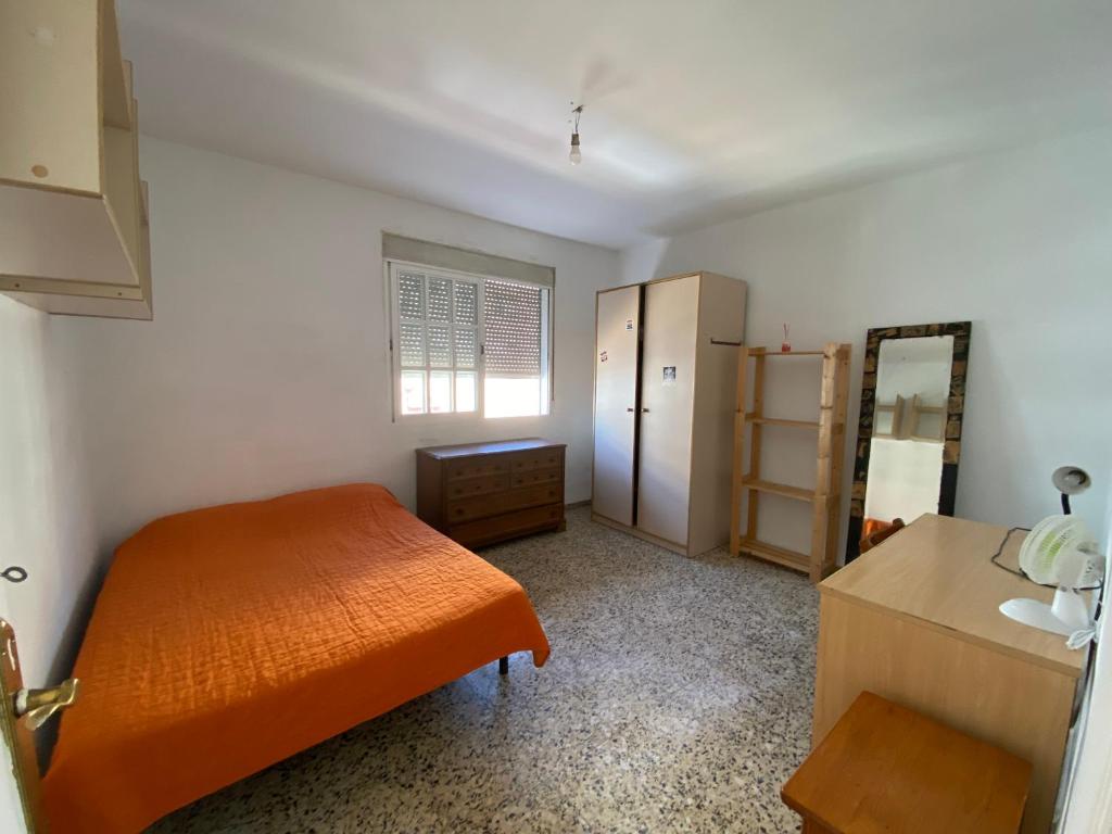 a bedroom with an orange bed and a mirror at BIGGER FLAT IDEAL PARA FAMILIA NEAR CENTER AND BEACH in Valencia