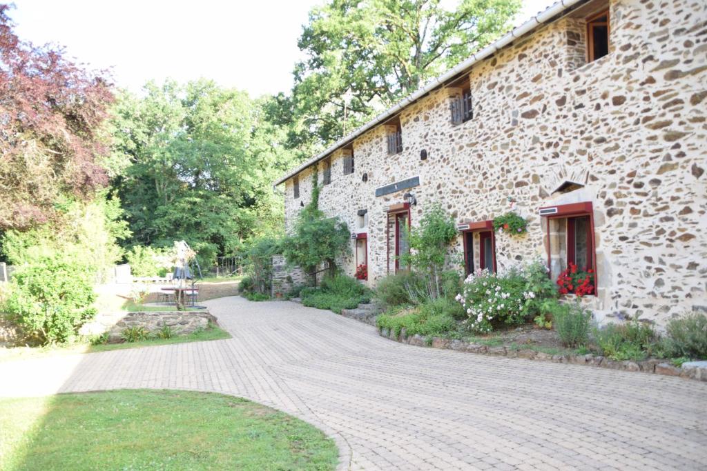 uma casa de pedra com uma entrada de calçada em LES 2 CHENES em Les Riffes