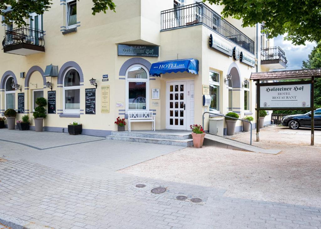 un edificio con una señal delante de él en Hotel-Restaurant Holsteiner Hof, en Geesthacht