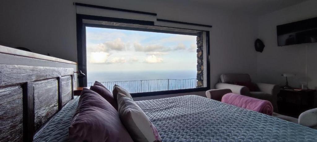 a bedroom with a large window with a view of the ocean at CASA LAS VISTAS in Fuencaliente de la Palma