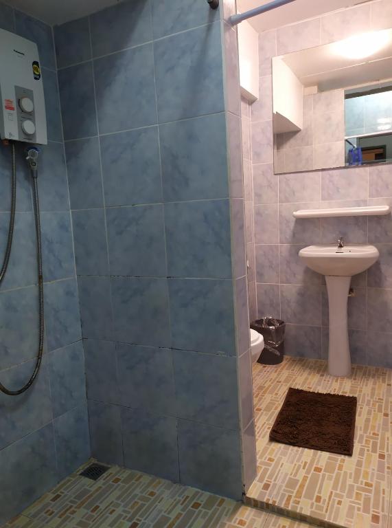 a bathroom with a shower with a toilet and a sink at Hooman Hostel in Chiang Mai