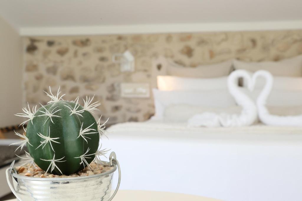 un cactus en un tazón en una mesa junto a una cama en Nasilvana Hotel & Spa Adults Only en Benimantell