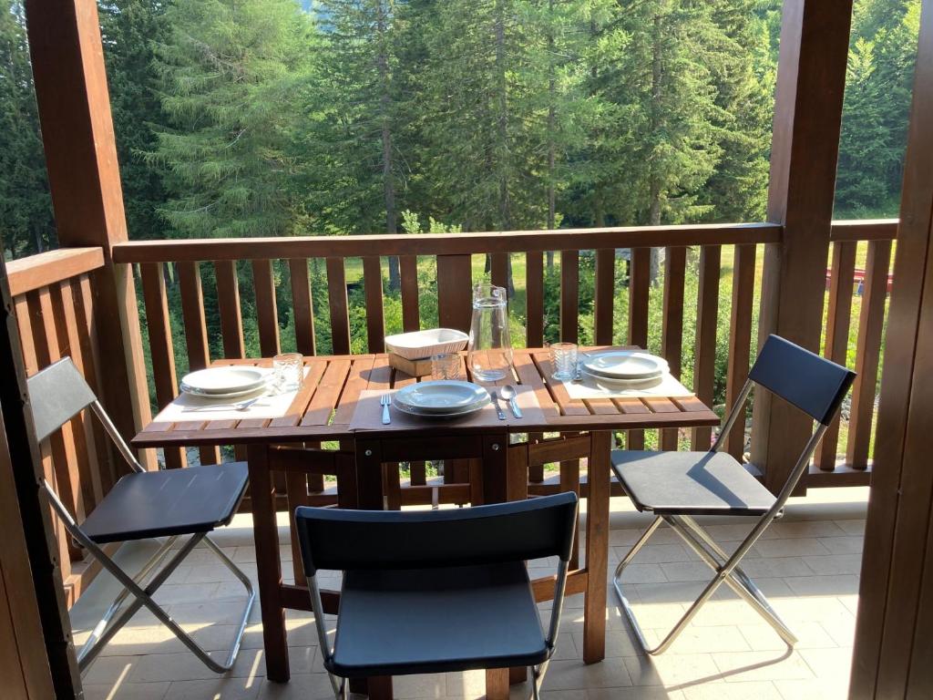 une table et des chaises en bois sur une terrasse avec vue dans l'établissement Casa Dalja, à Abetone