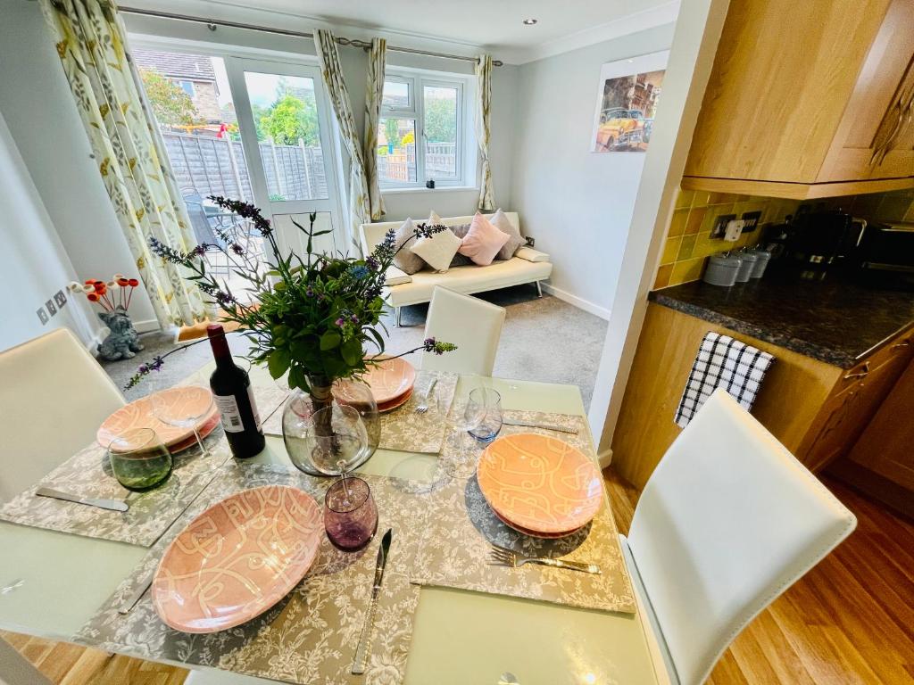 a kitchen with a table with plates on it at Cozy Bicester Village townhouse with garden in Bicester