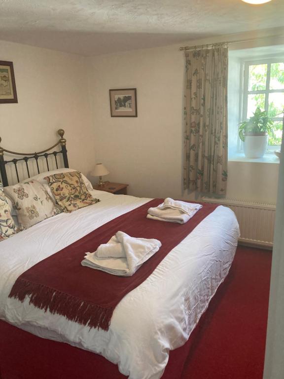 a bedroom with a bed with two towels on it at Bissick Old Mill in Truro