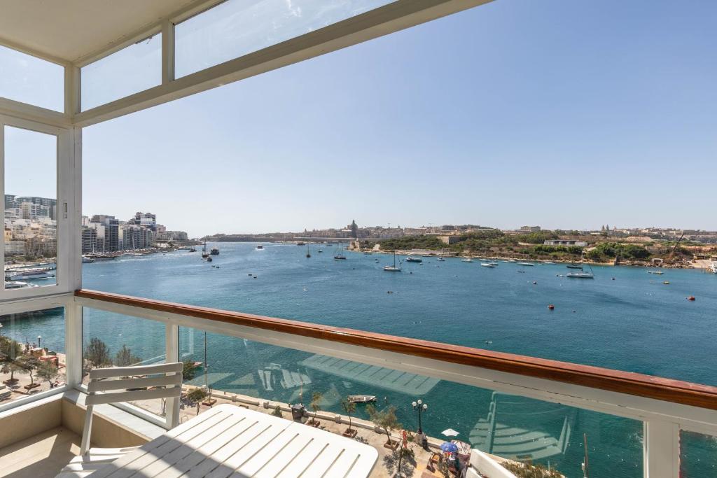 a balcony with a view of the water with boats at Stunning - Seafront 3-Bedroom 6th Floor in Sliema