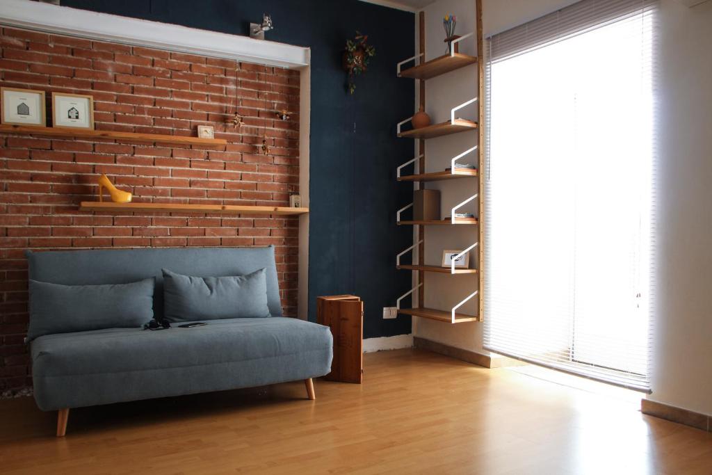 a living room with a couch and a brick wall at Gli Appartamenti Dell' Architetto in Trapani