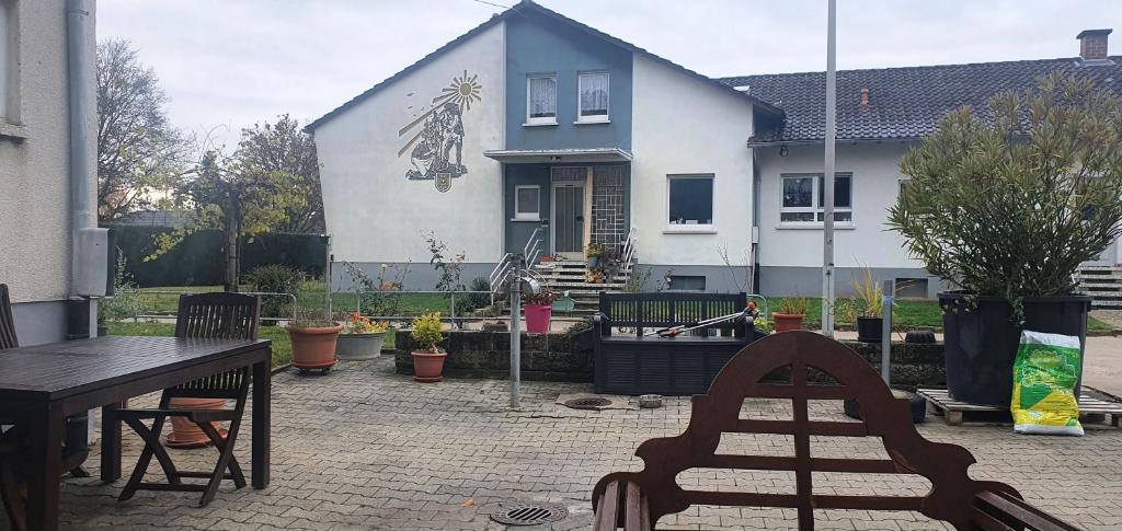 eine Terrasse mit einem Tisch und Stühlen vor einem Haus in der Unterkunft Gästehaus Maurer in Gau-Weinheim