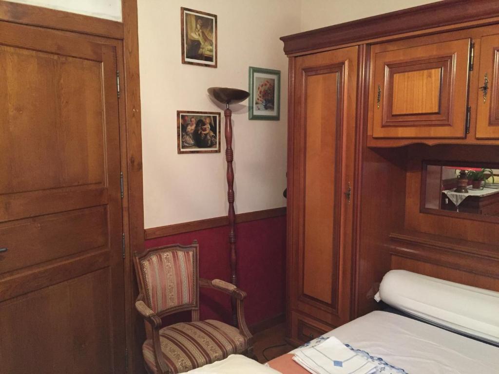 een kamer met een bed, een lamp en een stoel bij La Maison aux Roses in Vaux-en Couhé