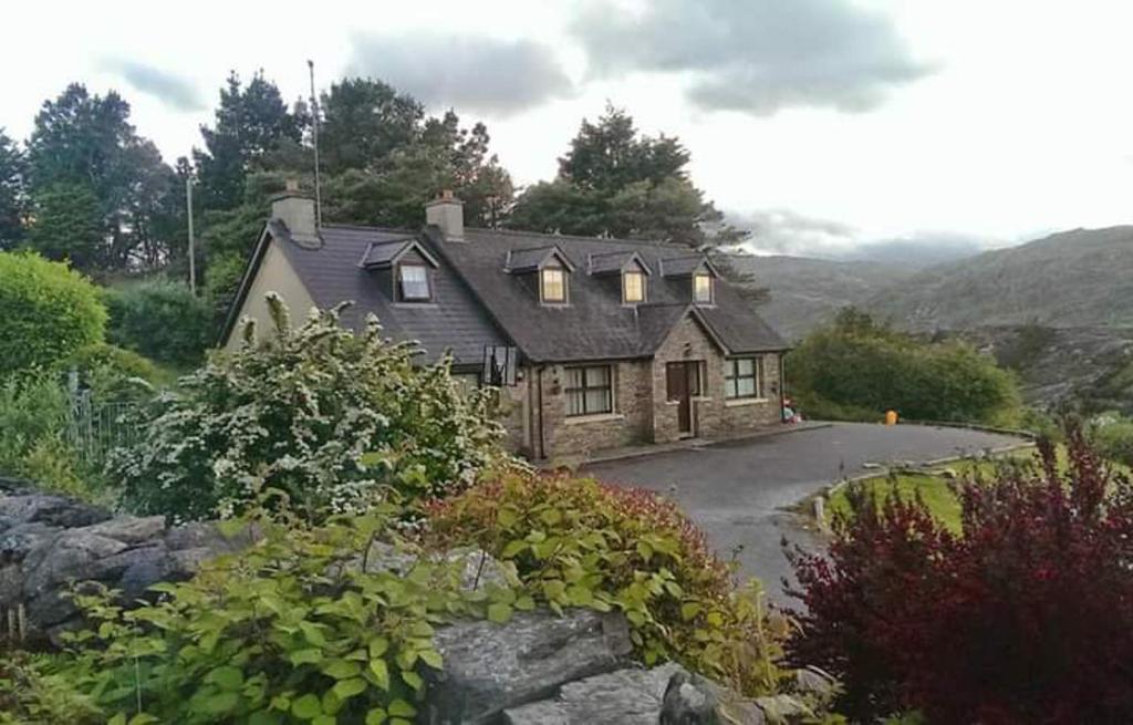 een huis op een heuvel met een weg bij Cuckoo Tree House Glengarriff Beara Peninsula in Glengarriff