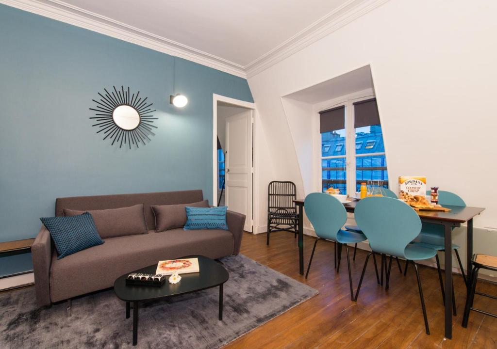 uma sala de estar com um sofá e uma mesa em Sweet Inn - Saint Honore em Paris