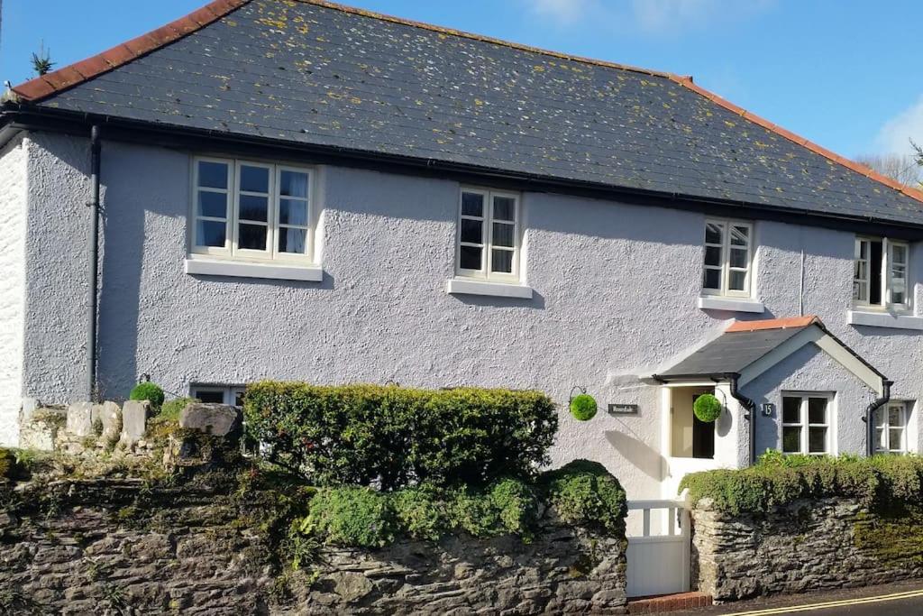 uma casa branca com uma parede de pedra em Rosedale a charming detached 4 bedroom cottage. em Brixham