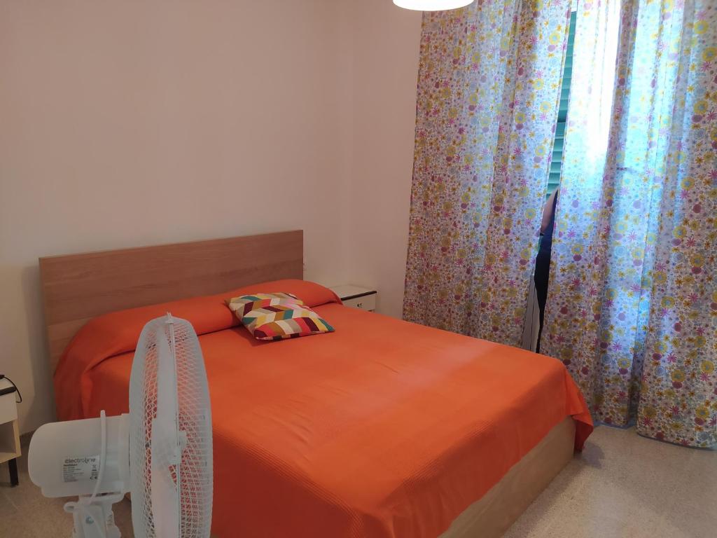 a bedroom with a bed with orange sheets and a window at MARE,BIKING, CLIMBING in Finale Ligure