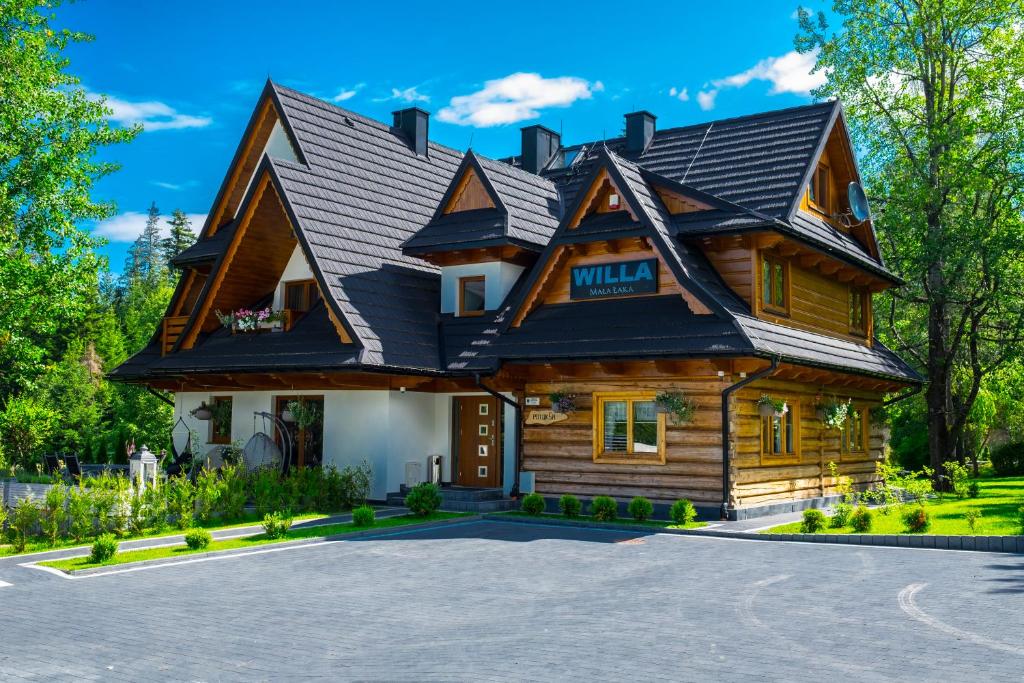 une grande maison en bois avec un toit en gambrel dans l'établissement Willa Mała Łąka, à Zakopane