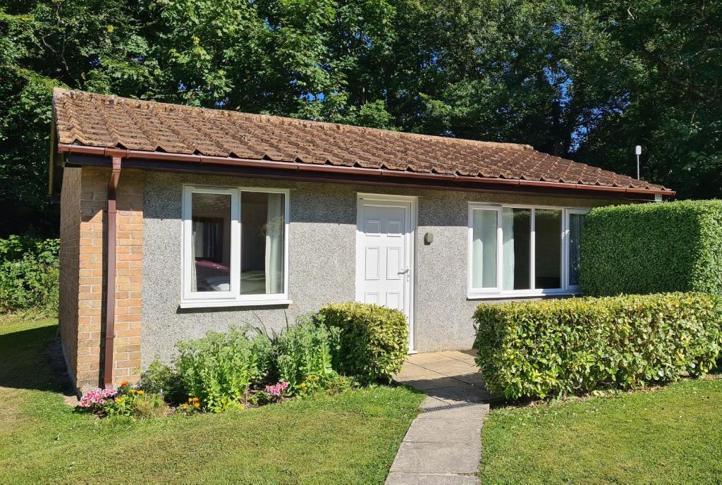 a small brick house with a white door at Detached Bungalow in North Cornwall in Bodmin