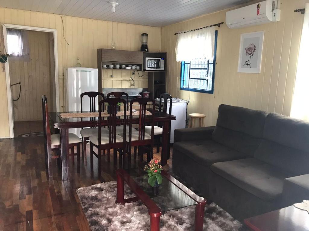 - un salon avec un canapé, une table et des chaises dans l'établissement RECANTO DA VÓ NINIDA, à Canela
