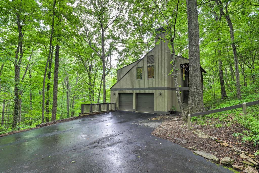 a house with a garage in the woods at Carriage House Near Blue Ridge Parkway and Downtown in Asheville