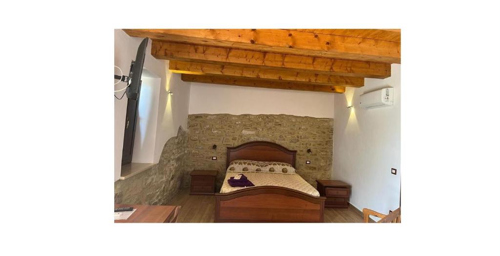 1 dormitorio con 1 cama en una pared de piedra en Agricoltura Rascio, en San Mauro Cilento