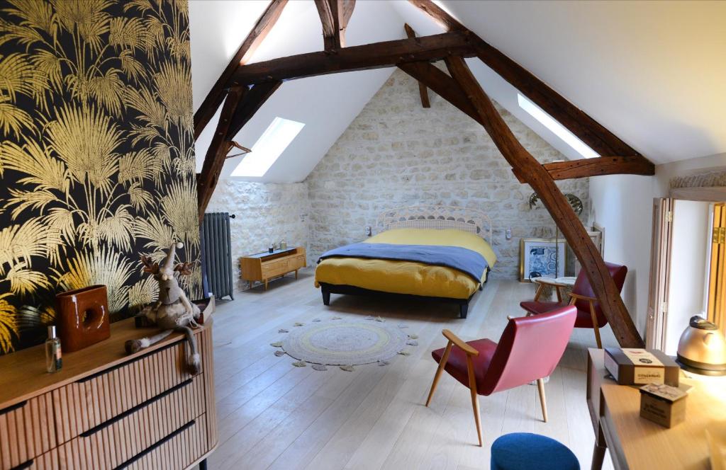 - une chambre avec un lit et une chaise dans l'établissement L’Artelier dans ma cour, à Hermonville