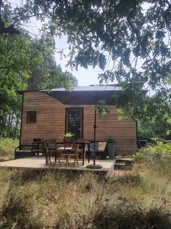 a small cabin with a table and chairs on a deck at Domaine Pinsol in Uchacq-et-Parentis