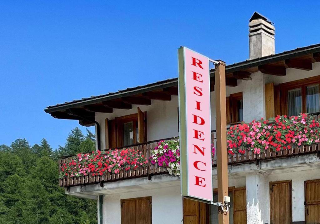 a hotel sign on the side of a building with flowers at Residence Nube D'Argento in Sestriere