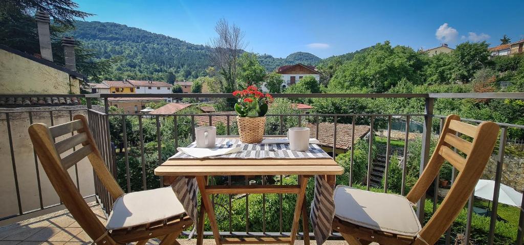 een houten tafel met 2 stoelen op een balkon bij Aufidena Apartment in Alfedena