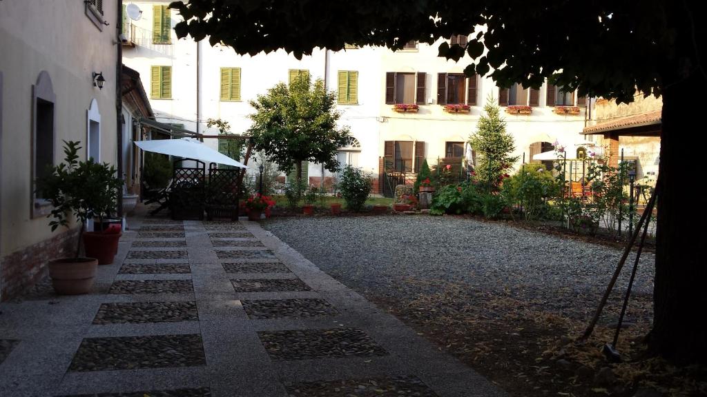an empty courtyard with a building and an umbrella at La Chicca B&B in Cassine
