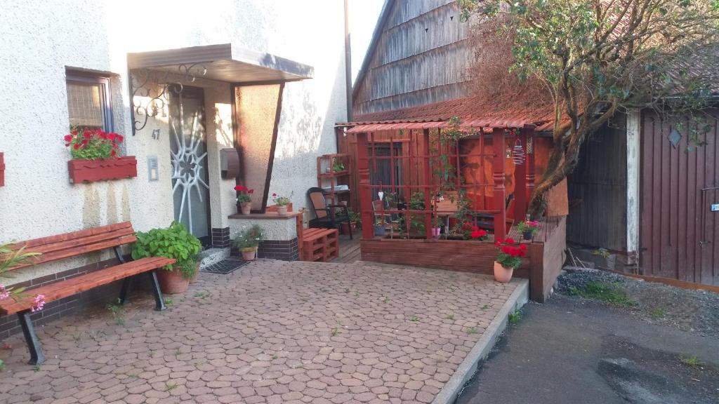 un patio avec un banc et un bâtiment dans l'établissement Ferienwohnung Vreni, à Gersfeld