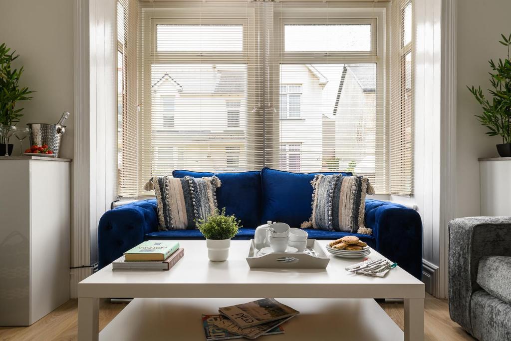 um sofá azul numa sala de estar com uma mesa em Fenton House - Modern, 4 Bedroom, Pets Accepted em Porthcawl