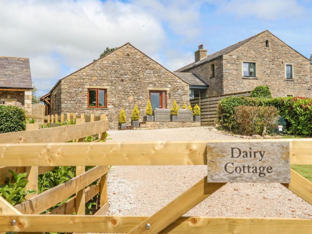 een stenen huis met een zuivelconferentie bord ervoor bij Dairy Cottage in Carnforth