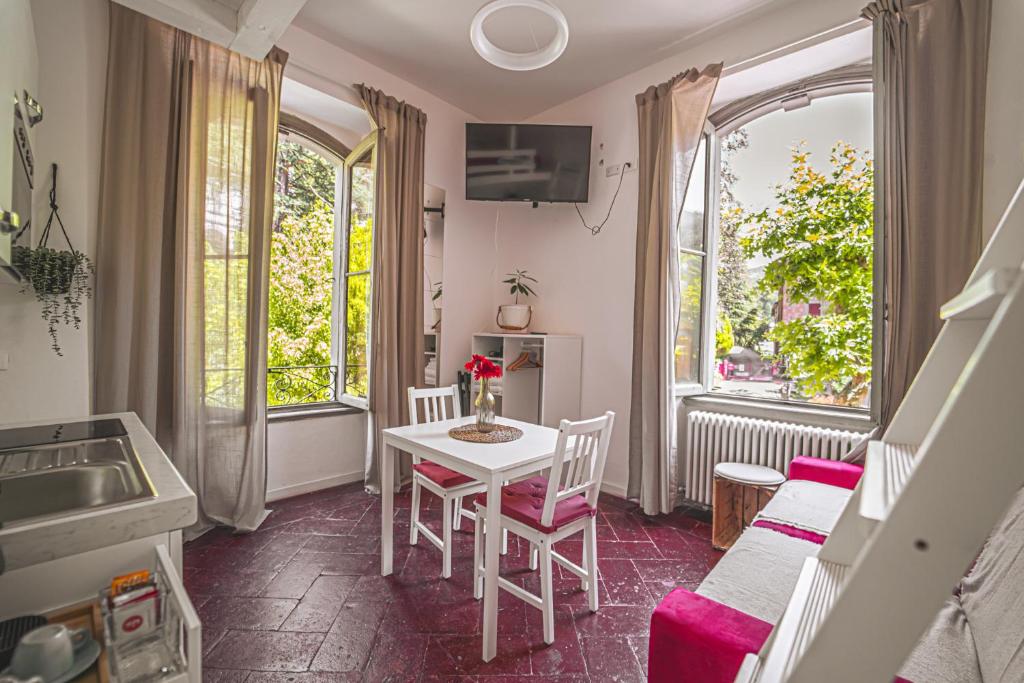 Habitación con mesa, sillas y ventana en LibertySuite Qcview2 en San Pellegrino Terme