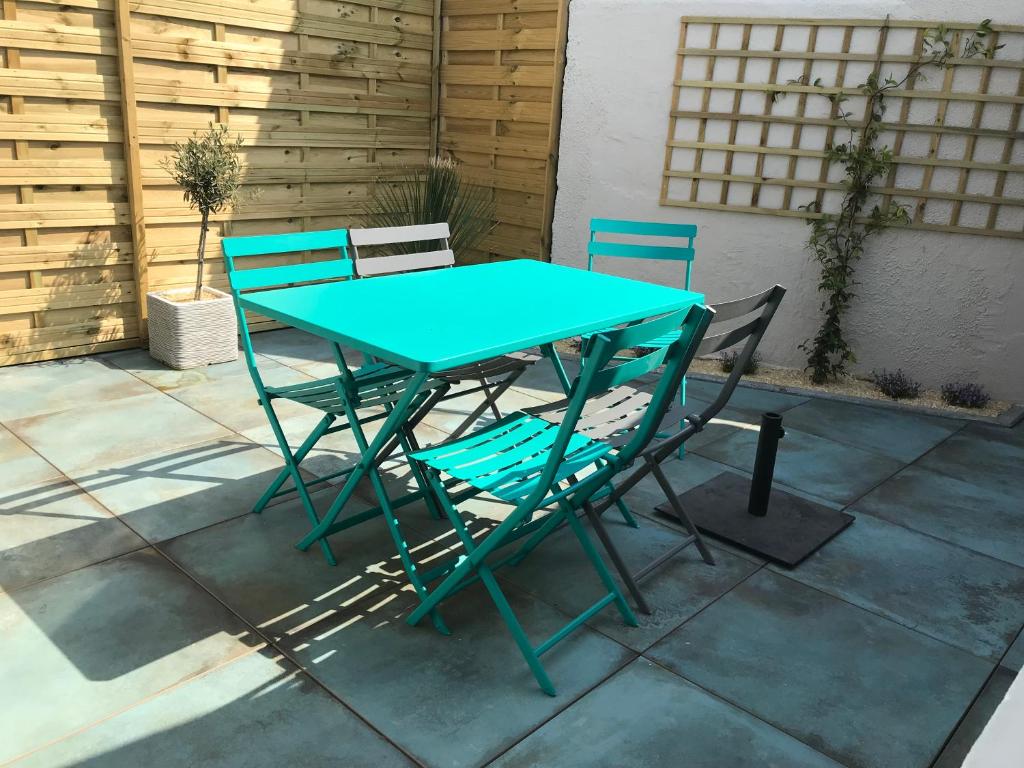 une table bleue et deux chaises sur la terrasse dans l'établissement La p’tite Hoguette, à Saint-Malo