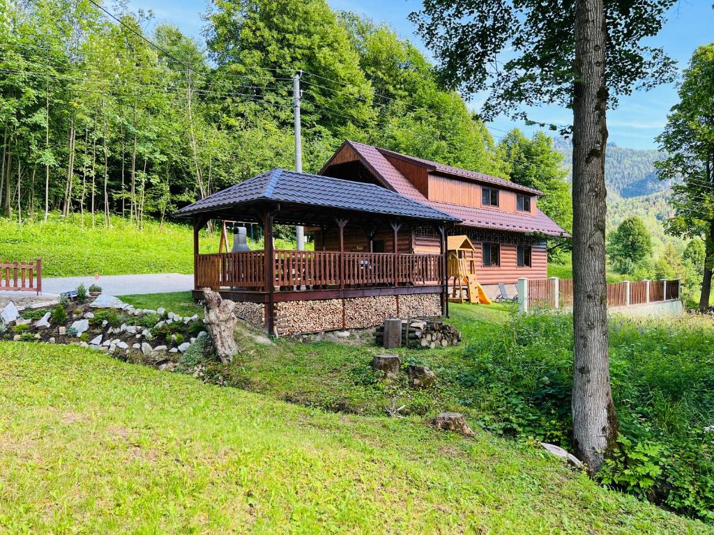 una grande cabina in legno con portico in un campo di Chata u Michala- neakceptujeme mladé partie a Terchová