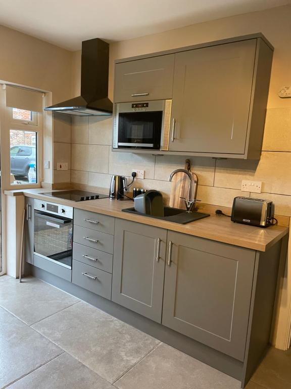 uma cozinha com um lavatório e um fogão forno superior em Northorpe Cottage em Hornsea