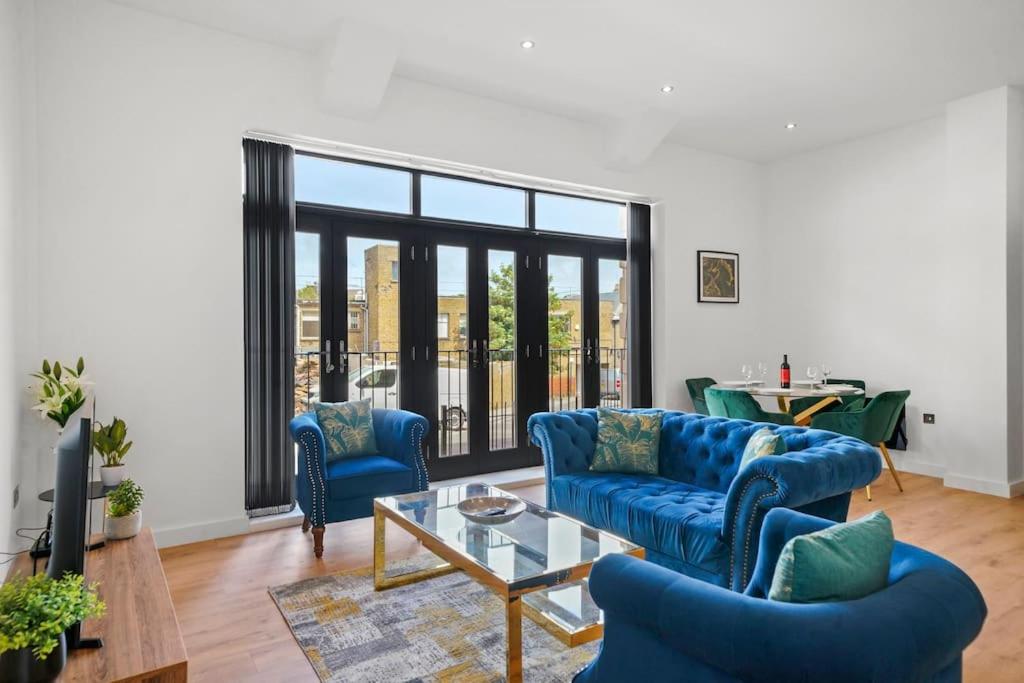 een woonkamer met blauwe banken en een tafel bij Luxury Split Level 2 Bed Apartment in Ramsgate