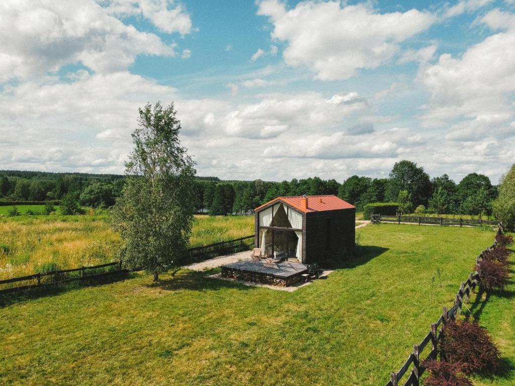 an old barn in a field with a fence at Fejny Dom - Jezioro Dadaj in Kromerowo