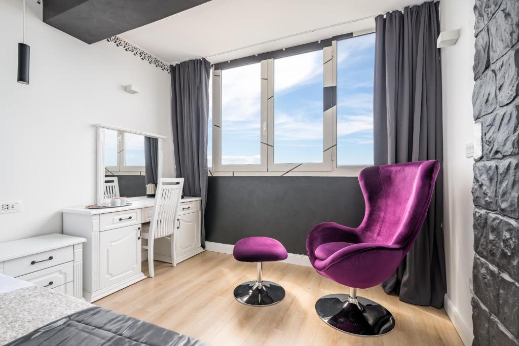 a bedroom with a purple chair and a desk at Charming in Split