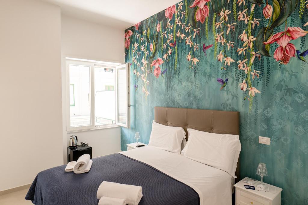 薩雷諾的住宿－Relais Vittorio Veneto - Luxotel & Apartotel，一间卧室配有一张带花卉壁纸的床