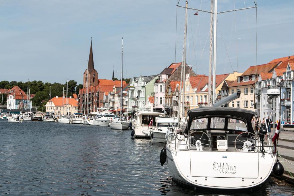 a boat is docked in a harbor with other boats at City Harbour House in Sønderborg