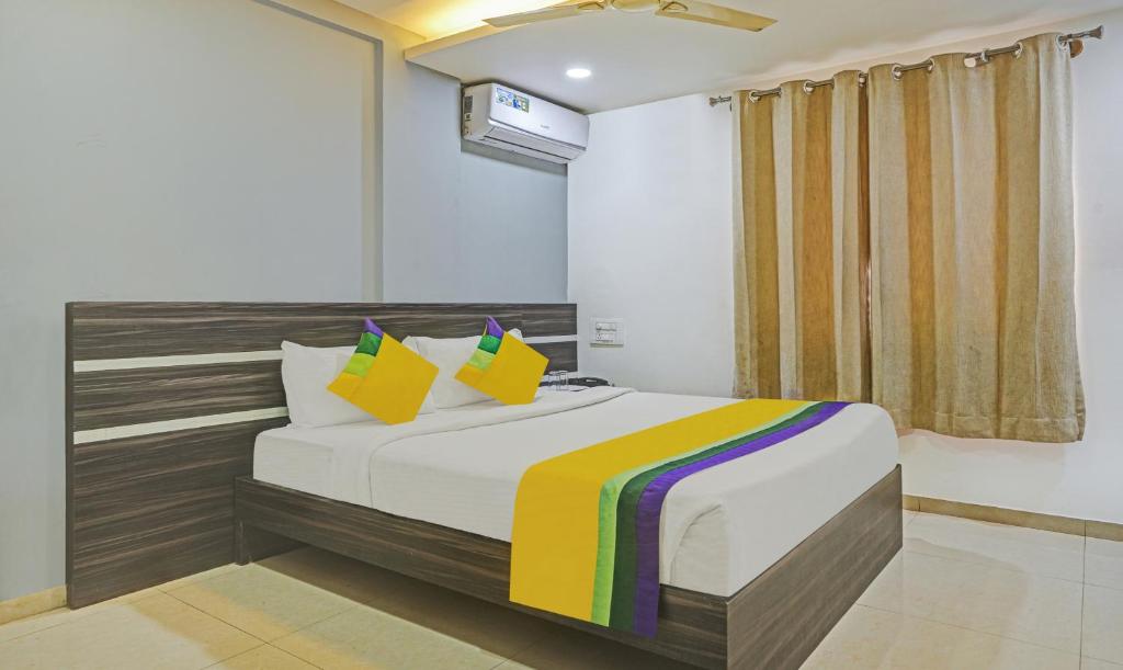a bedroom with a large bed with colorful pillows at Itsy Hotels Purple Suites in Bengaluru