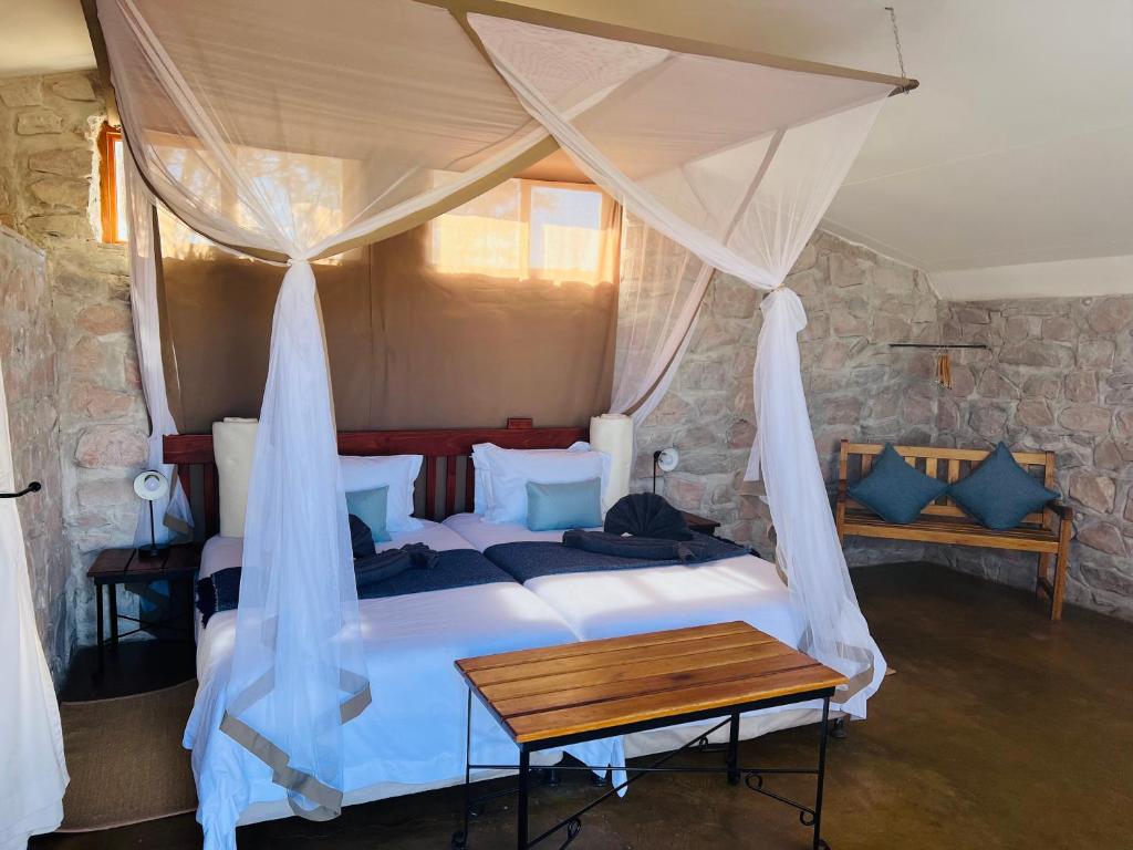 a bedroom with a bed with a canopy at Little Sossus Lodge in Sesriem