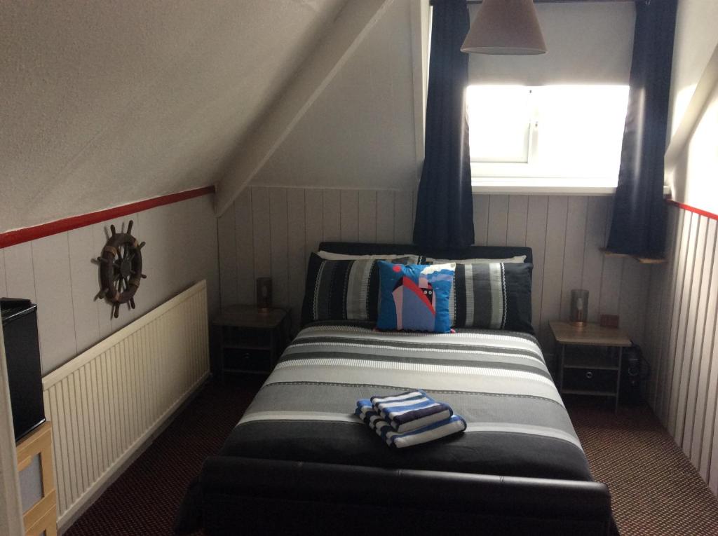 a small room with a bed in a attic at Snowdon House Single rooms for solo travellers in Rhyl