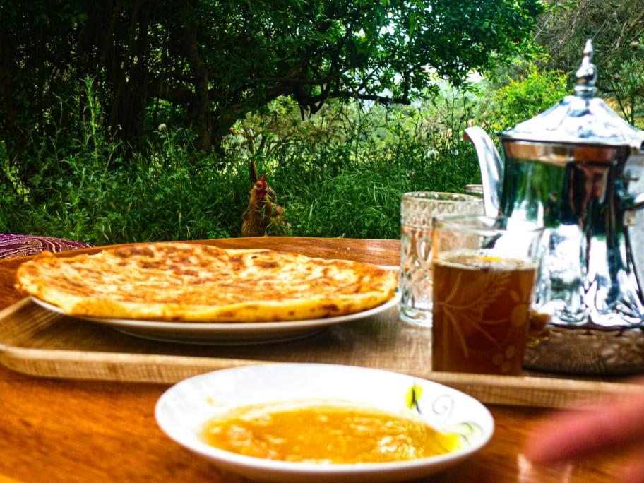 een tafel met een kaaspizza en een drankje erop bij GITE TAGMA in Berkane