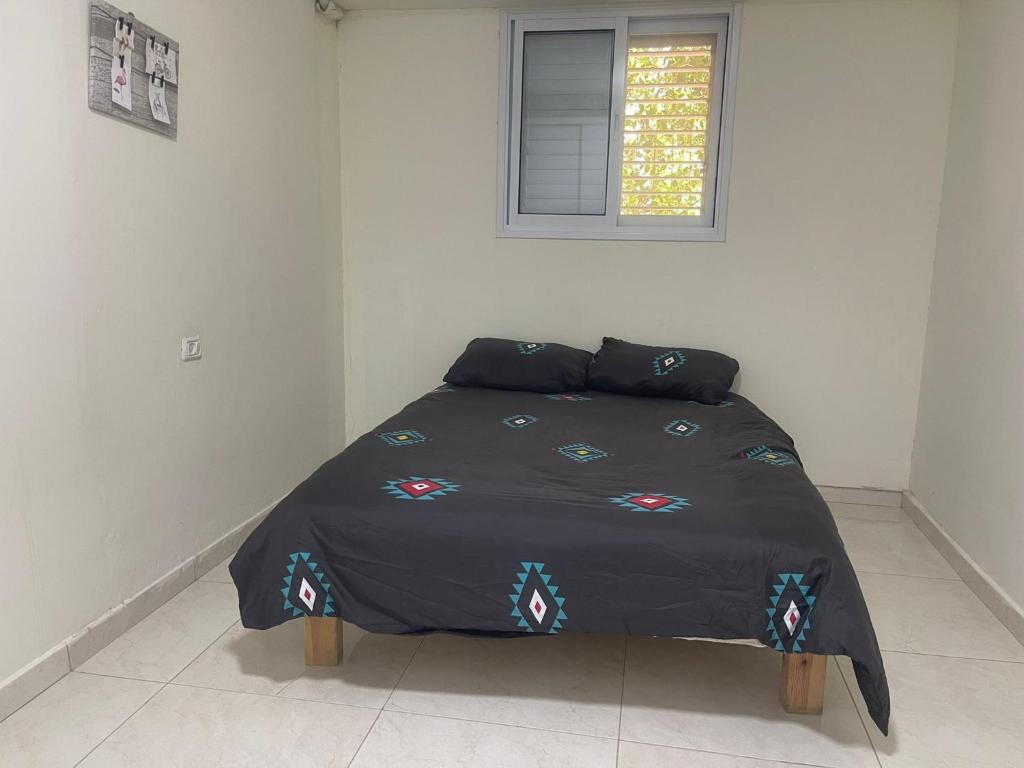 uma cama com um edredão preto num quarto em דירות אירוח לכל מטרה em Bersebá