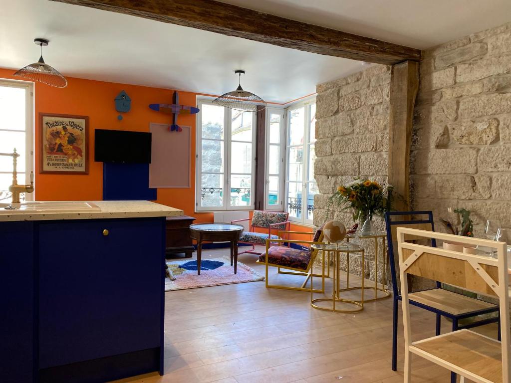 cocina y sala de estar con paredes de color naranja en Logement entier - L'Appart des anges 1, en Noyers-sur-Serein