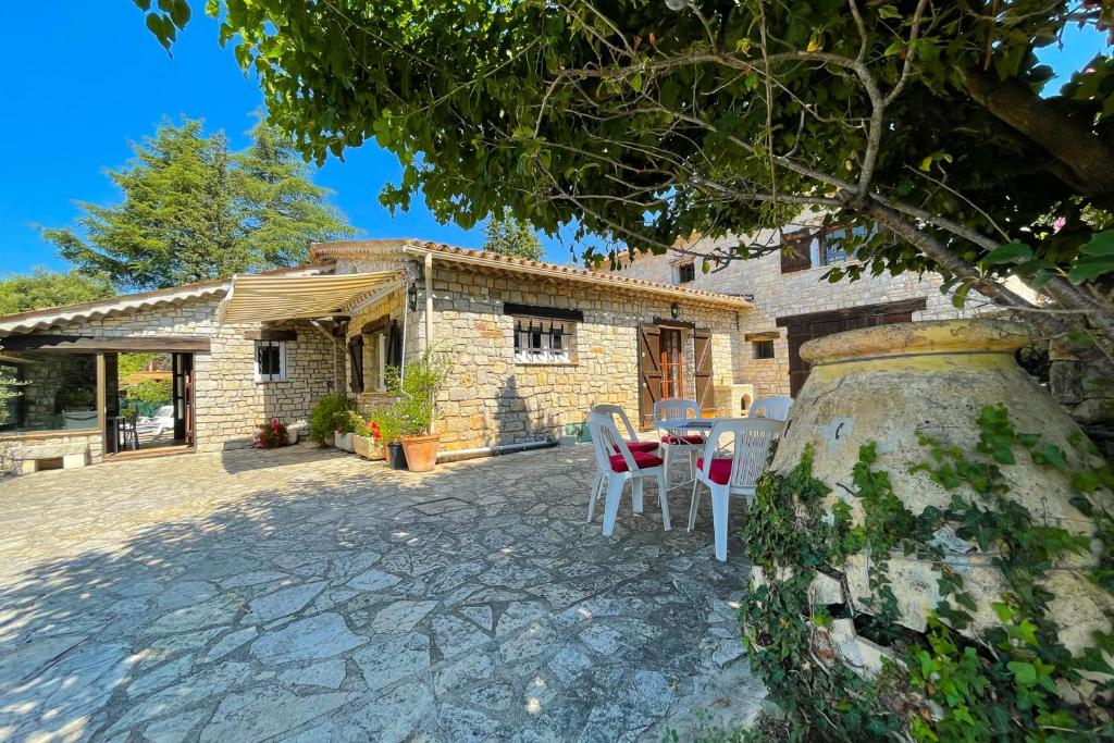 patio ze stołem i krzesłami przed domem w obiekcie Farmhouse 6 pers in Peymeinade - 20 min from Cannes w mieście Peymeinade